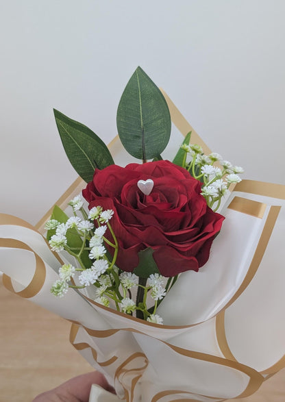 Bouquet of red roses with a heart-shaped object on a decorative card