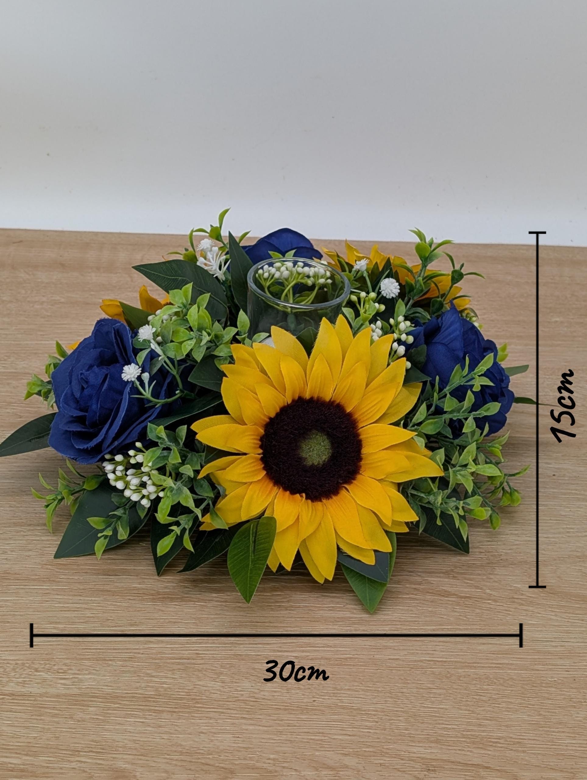Floral arrangement with sunflower, roses, and greenery on a wooden surface with measurements.