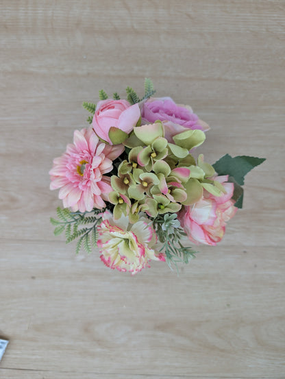 Artificial flower arrangement on a wooden surface