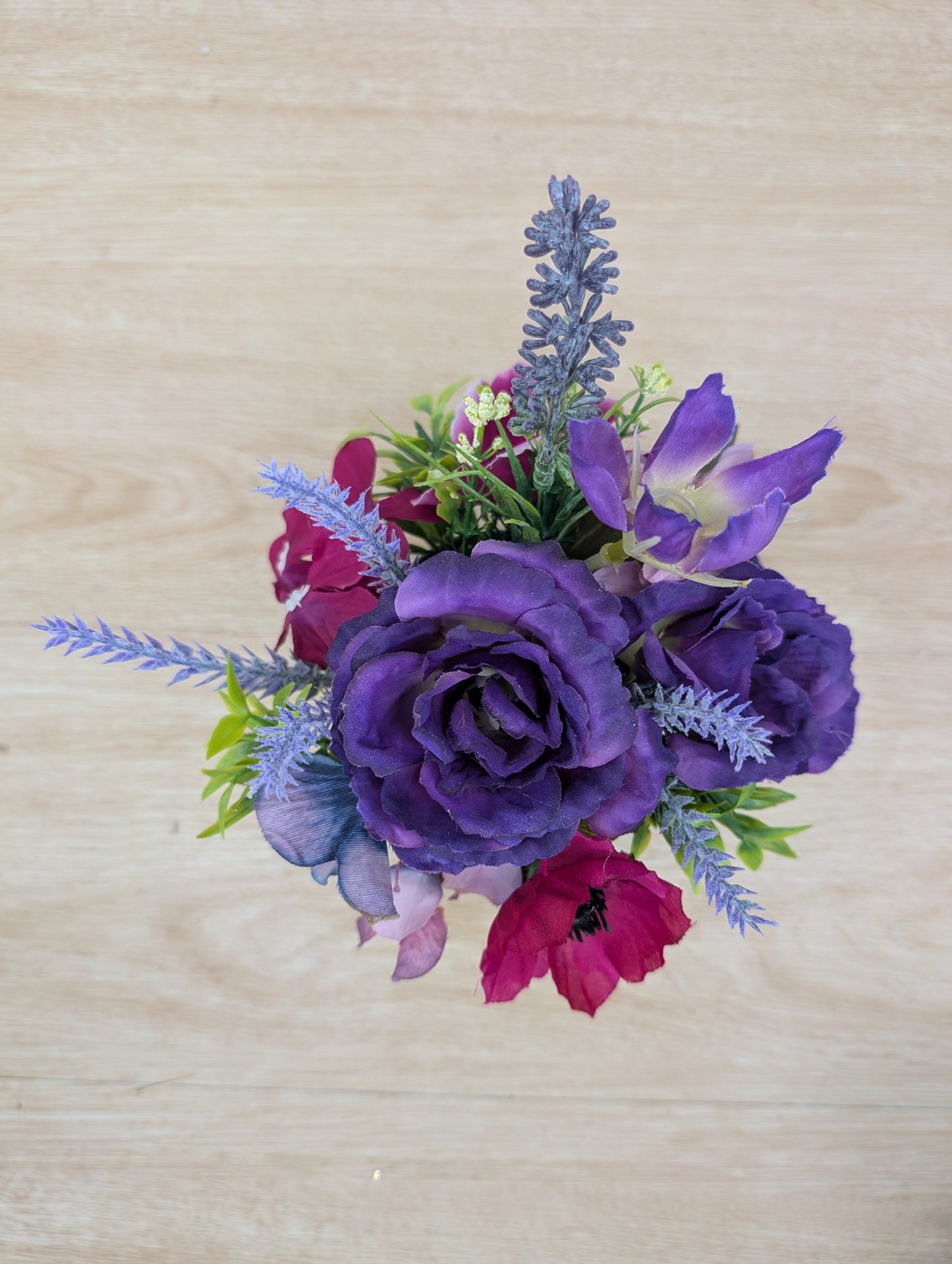 Bouquet of purple and pink flowers on a wooden surface
