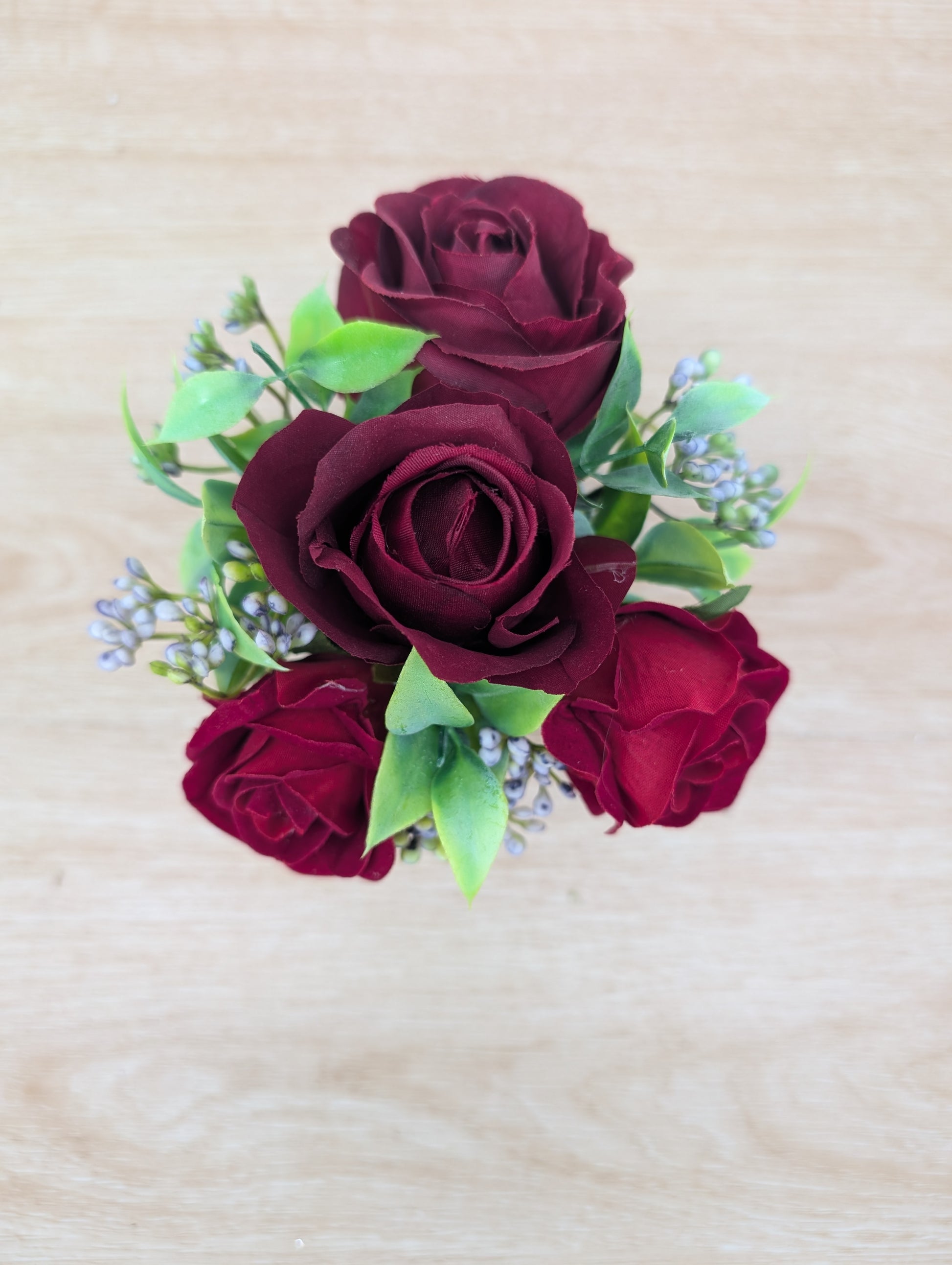 Bouquet of red roses with green leaves on a beige background